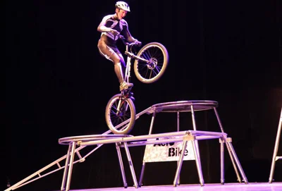 Acrobate en vélo sur une structure métallique